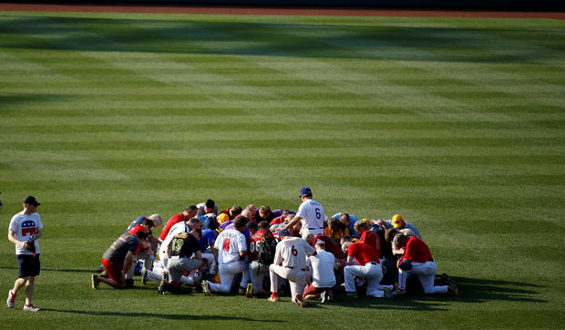 Teams pray. Reuters: Joshua Roberts